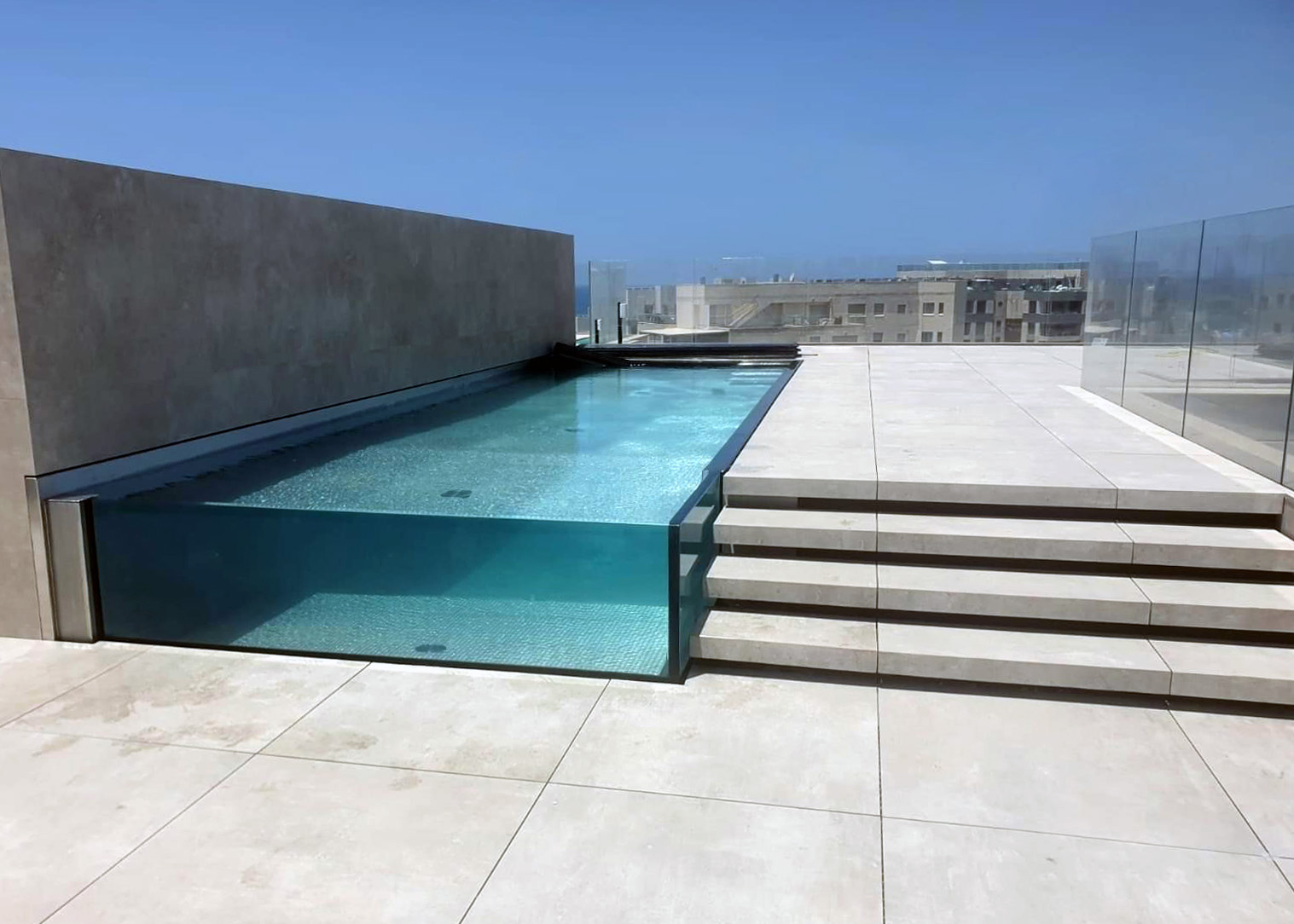 Luxury rooftop stainless-steel pool with glass walls by IMAGINOX