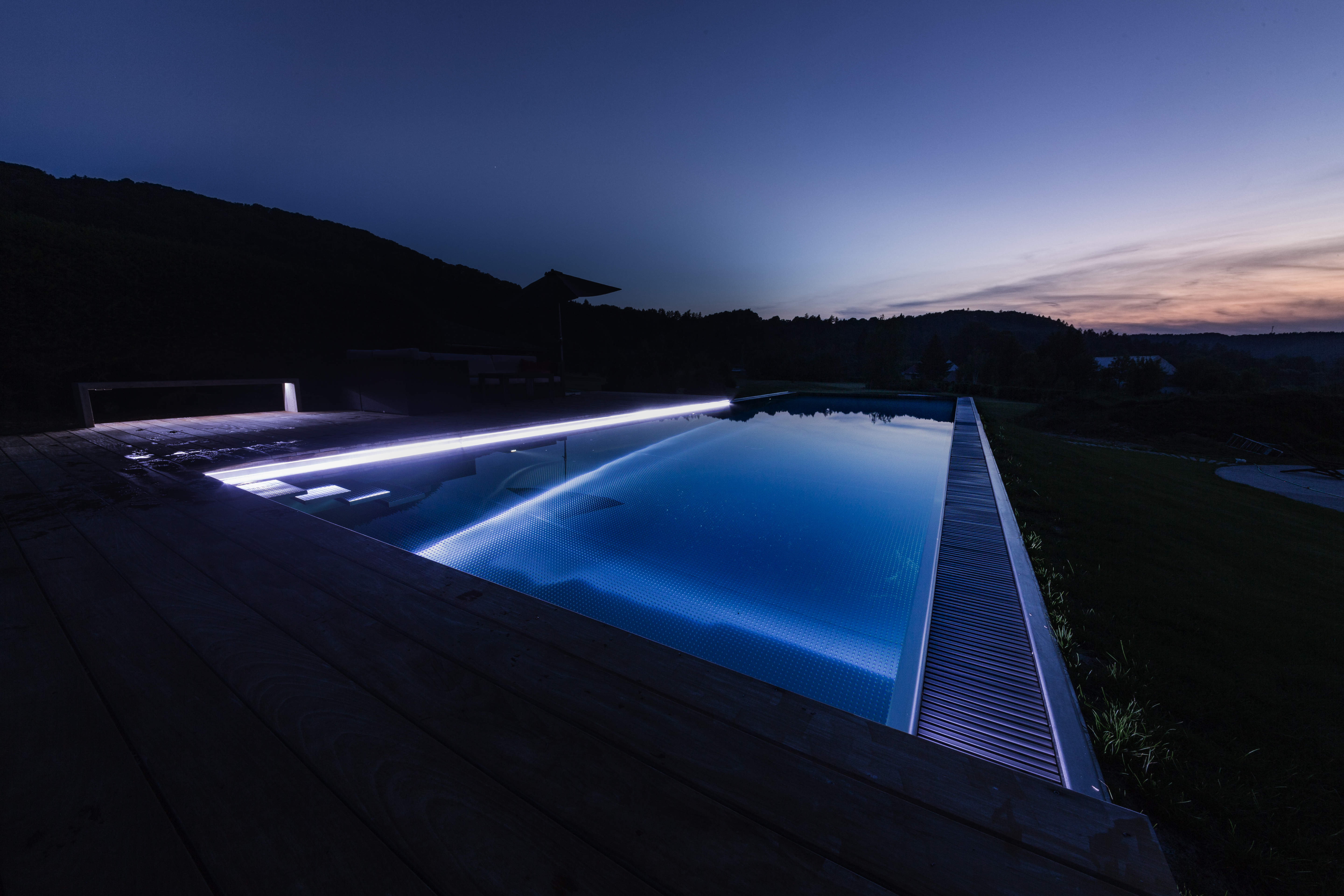 Infinity pool with negative edge and glass walls by IMAGINOX